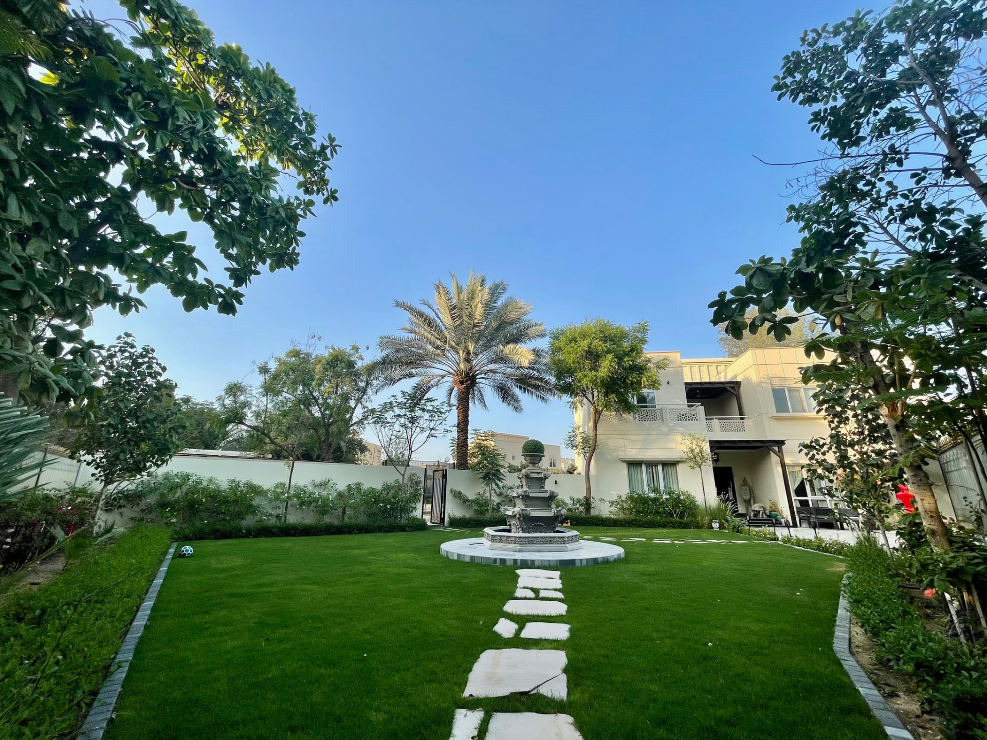 The villa at KANDEEBAM overlooking a manicured lawn and fountain