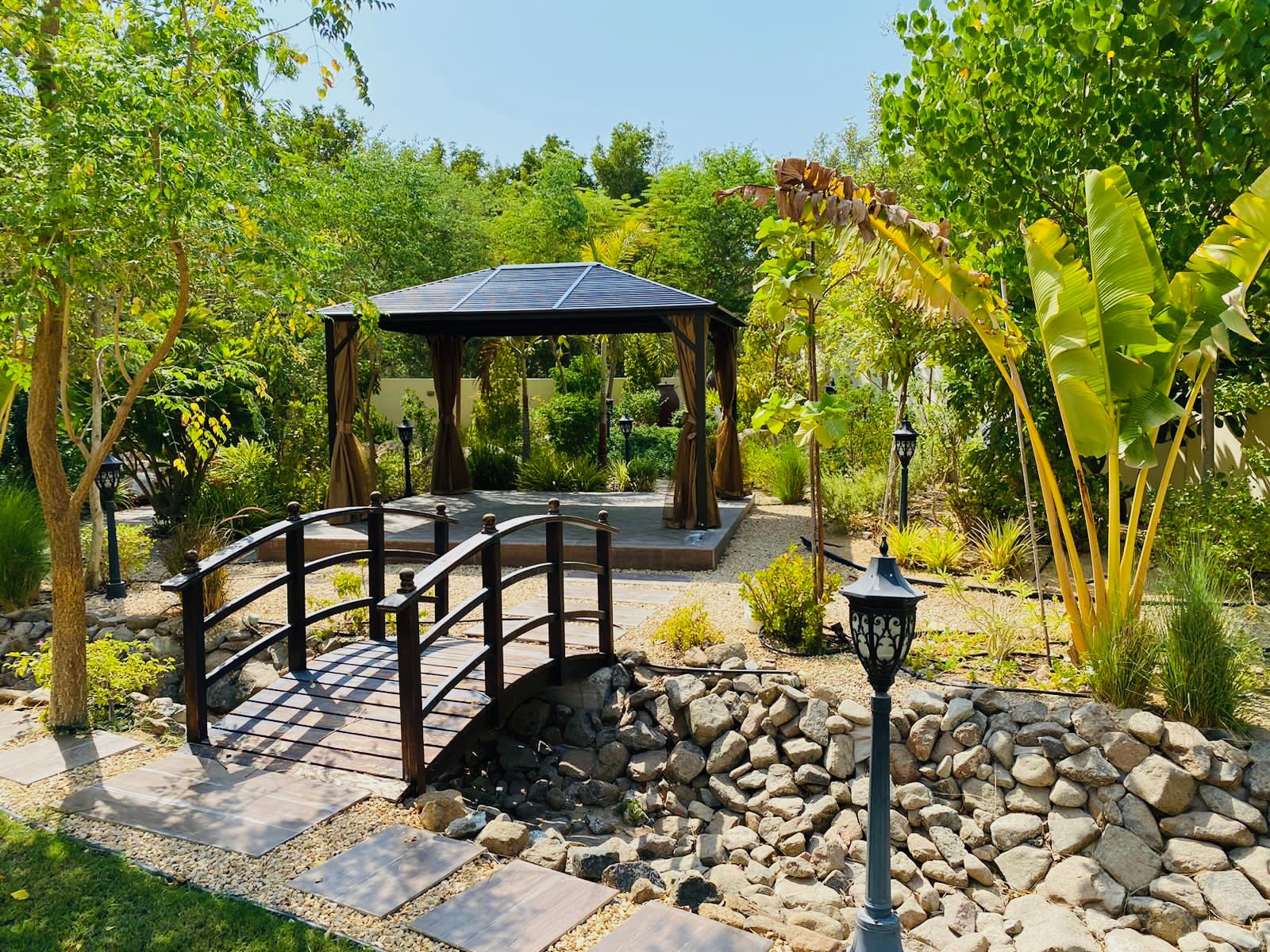 Garden pavilion surrounded by lush trees at KANDEEBAM residence